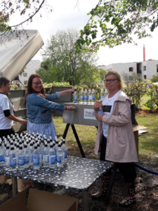 Martina Boson med kollega delar ut vattenflaskor 