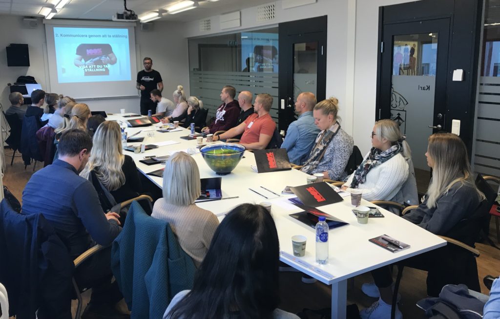 Bild på deltagare i utbildningen. Sitter ner vid ett konferensbord.