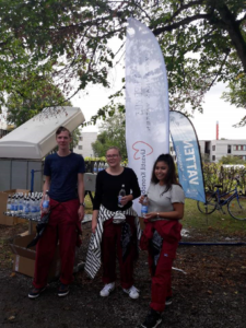 Tre studenter hjälper till att dela ut vattenflaskor till andra studenter
